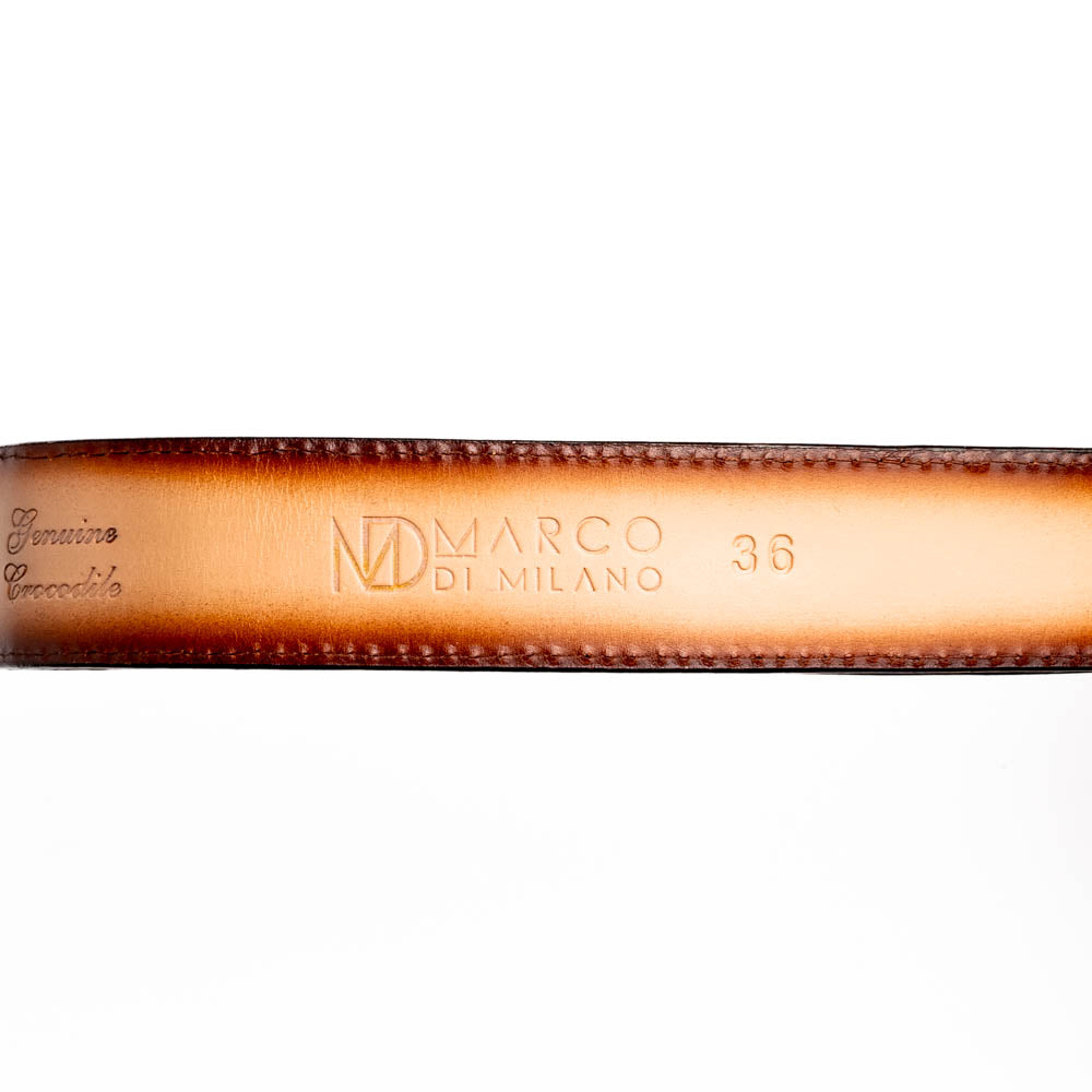 The Marco Di Milano Iowa Belt Stone Brown features genuine caiman crocodile leather, a gold "MD" buckle, and "Marco Milano" engraved on the side, evoking a classic western style against a white background.