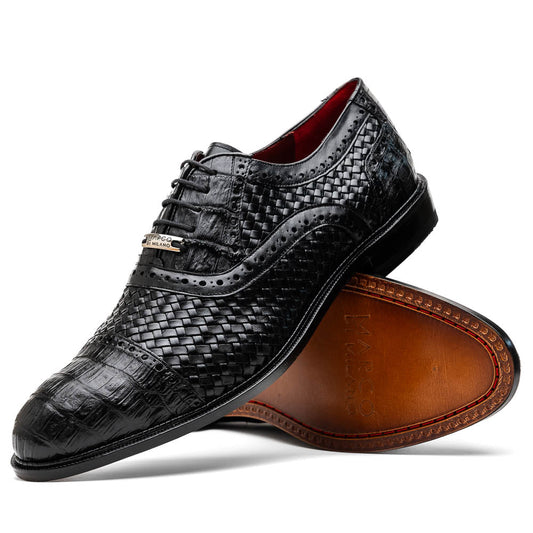 A pair of luxury "John Black" dress oxfords by Marco Di Milano, crafted from genuine caiman crocodile leather with intricate detailing and brown leather soles—one upright, the other resting sideways beneath it.