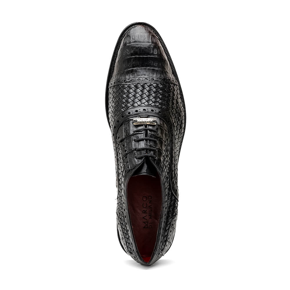 A pair of luxury "John Black" dress oxfords by Marco Di Milano, crafted from genuine caiman crocodile leather with intricate detailing and brown leather soles—one upright, the other resting sideways beneath it.