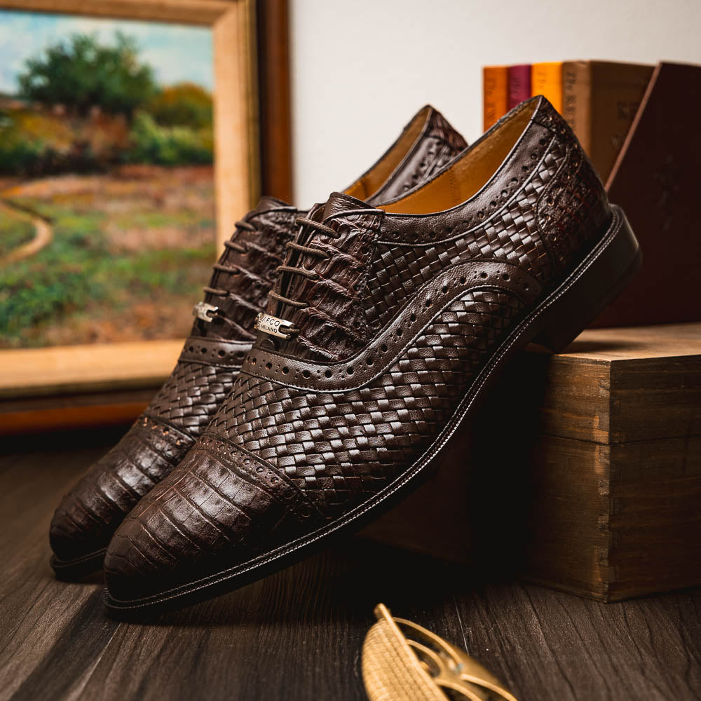 A pair of John Brown luxury dress oxfords by Marco Di Milano in brown woven calfskin leather with brogue detailing; one shoe upright, the other displays the sole and "Marco Di Milano" branding.