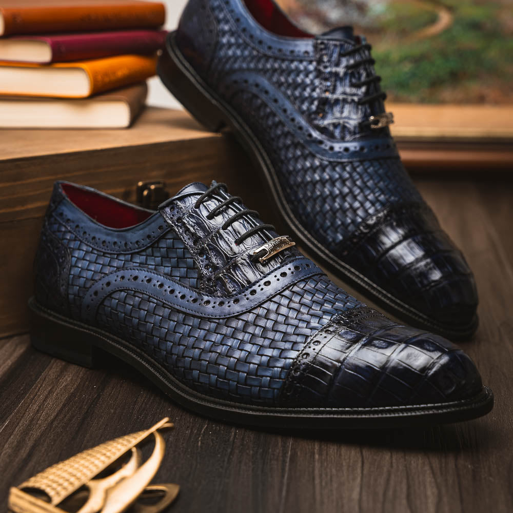 Introducing the Marco Di Milano John Navy: luxury dark blue woven oxford shoes in genuine caiman crocodile leather, with one shoe showing the sole and the other upright.