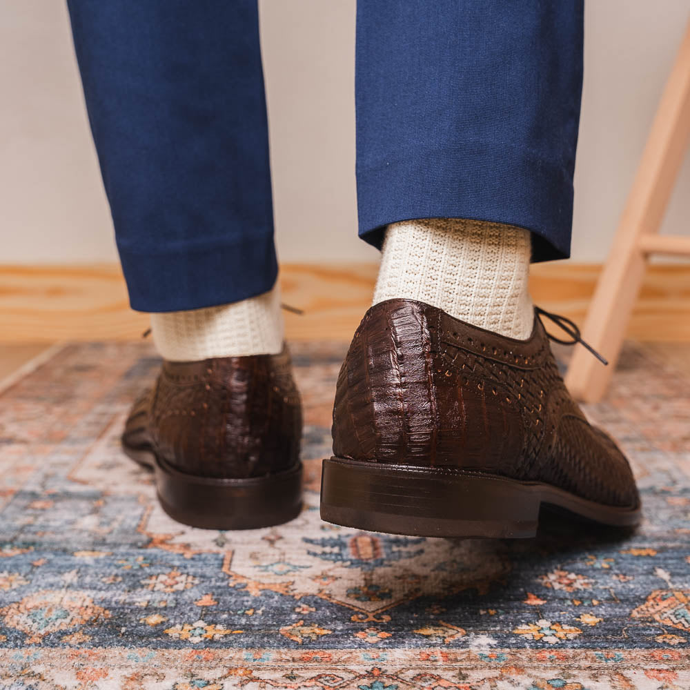 A pair of John Brown luxury dress oxfords by Marco Di Milano in brown woven calfskin leather with brogue detailing; one shoe upright, the other displays the sole and "Marco Di Milano" branding.