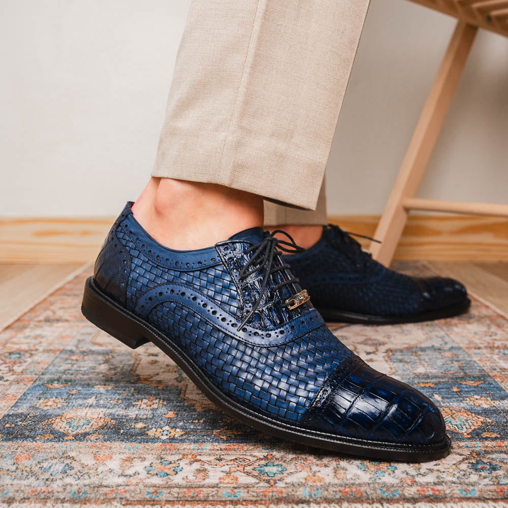 Introducing the Marco Di Milano John Navy: luxury dark blue woven oxford shoes in genuine caiman crocodile leather, with one shoe showing the sole and the other upright.