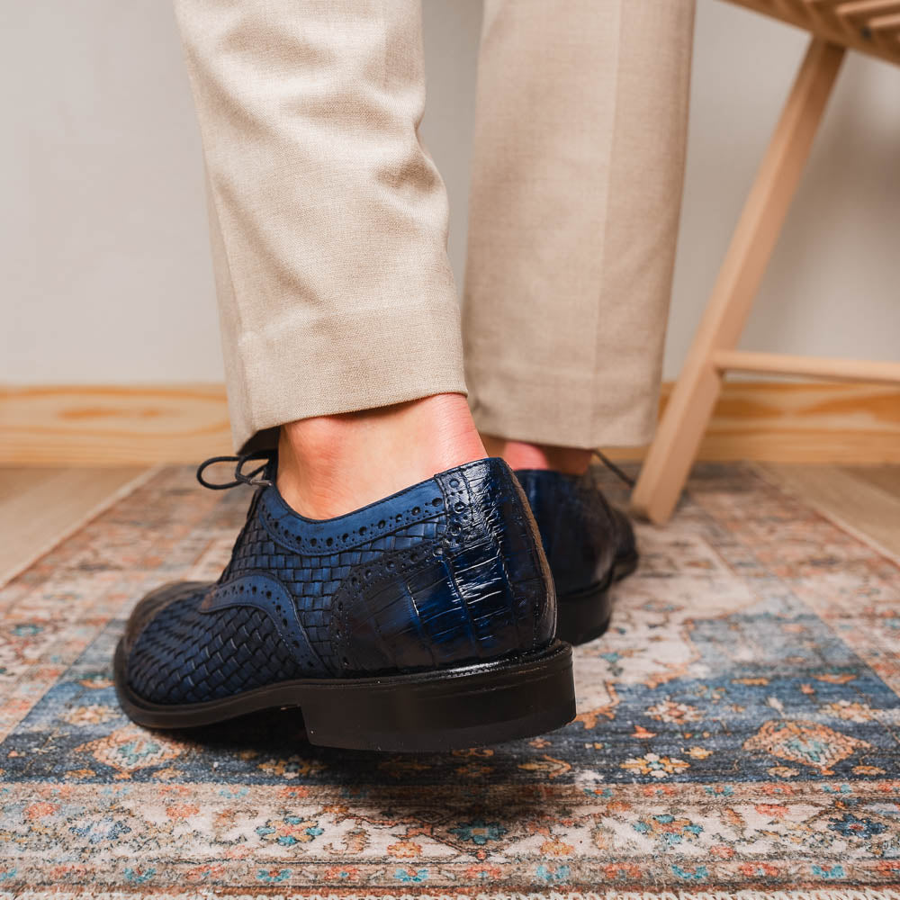 Introducing the Marco Di Milano John Navy: luxury dark blue woven oxford shoes in genuine caiman crocodile leather, with one shoe showing the sole and the other upright.
