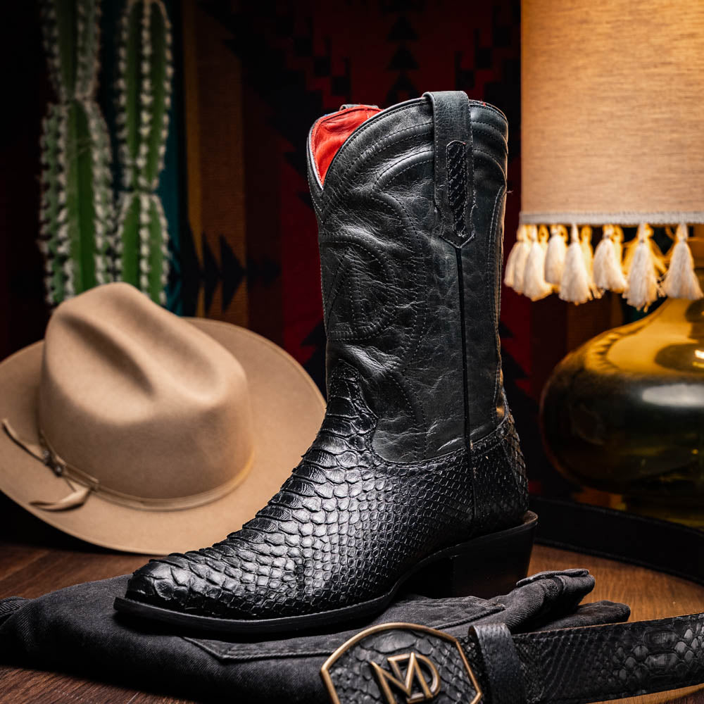 A pair of Kansas Black genuine python boots by Marco Di Milano, one upright and one on its side showing the branded sole.