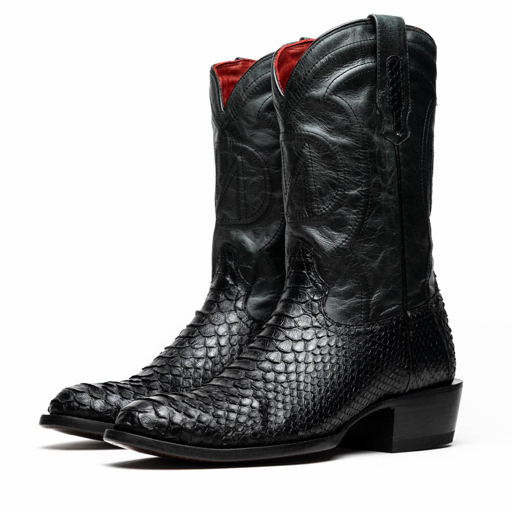A pair of Kansas Black genuine python boots by Marco Di Milano, one upright and one on its side showing the branded sole.