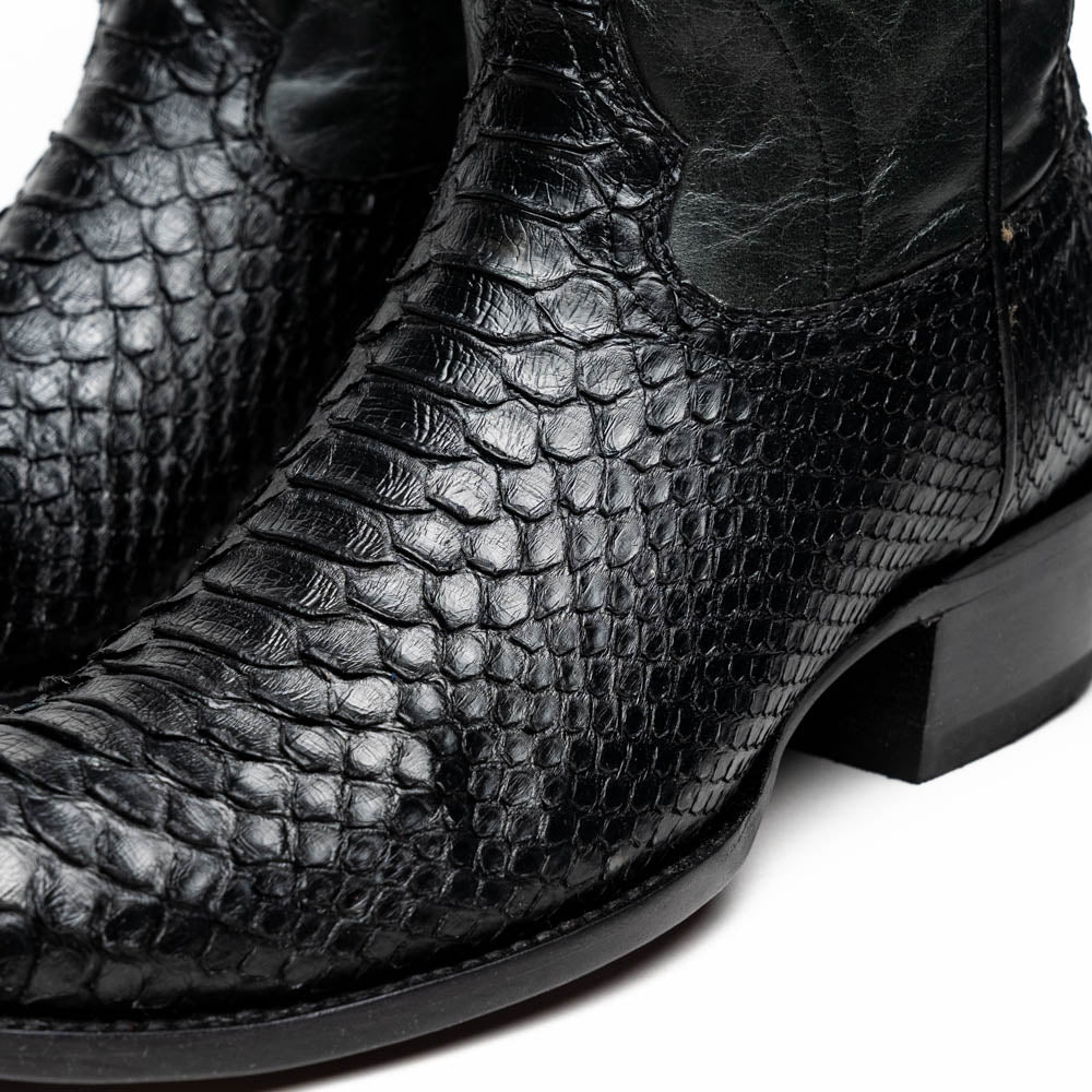 A pair of Kansas Black genuine python boots by Marco Di Milano, one upright and one on its side showing the branded sole.