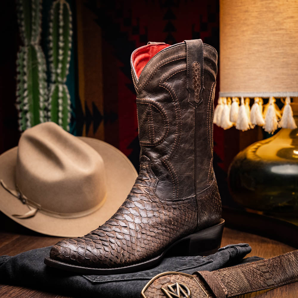 A pair of Kansas Brown textured luxury western boots by Marco Di Milano, featuring a pointed toe—one boot upright, the other showing the brand's logo on the leather sole.