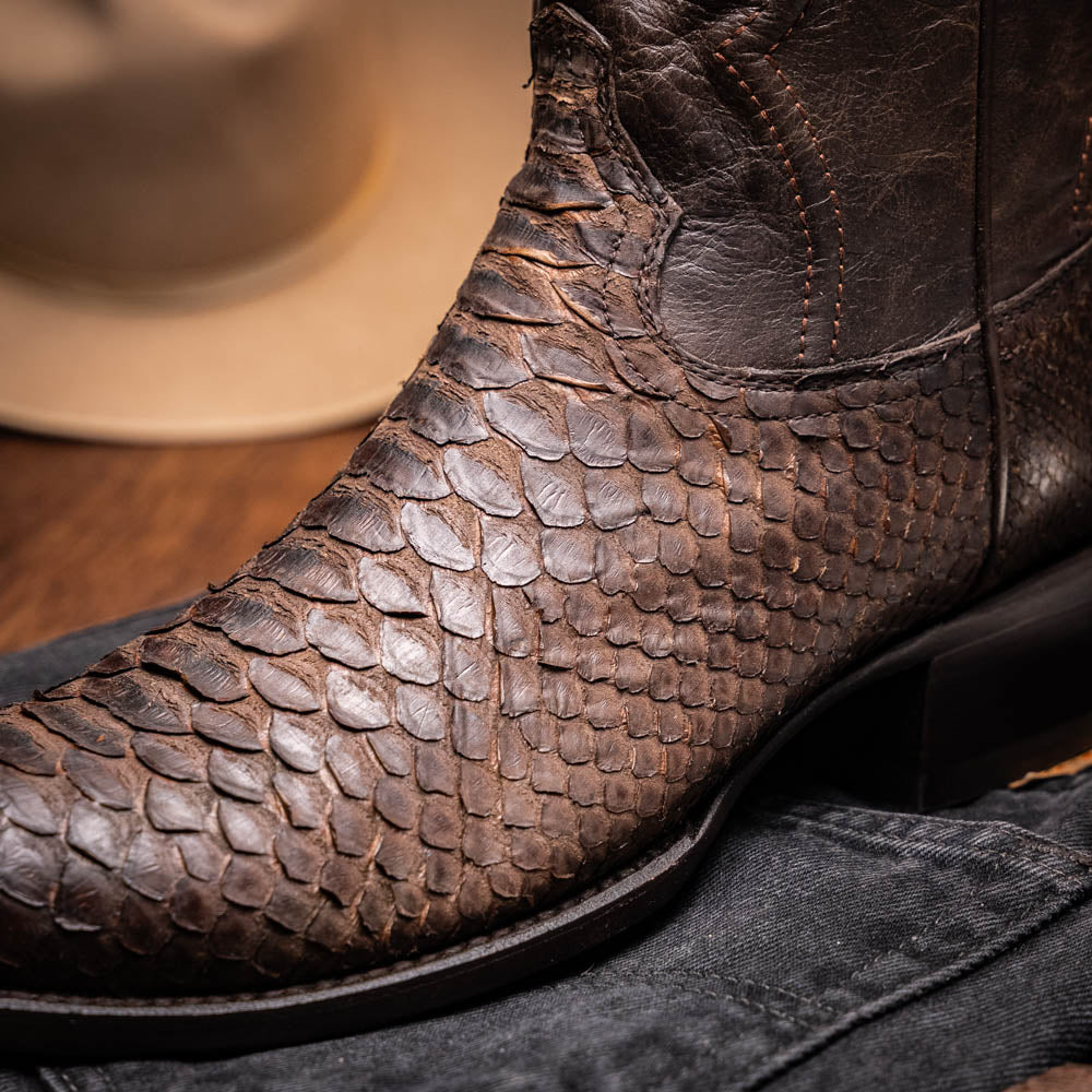 A pair of Kansas Brown textured luxury western boots by Marco Di Milano, featuring a pointed toe—one boot upright, the other showing the brand's logo on the leather sole.