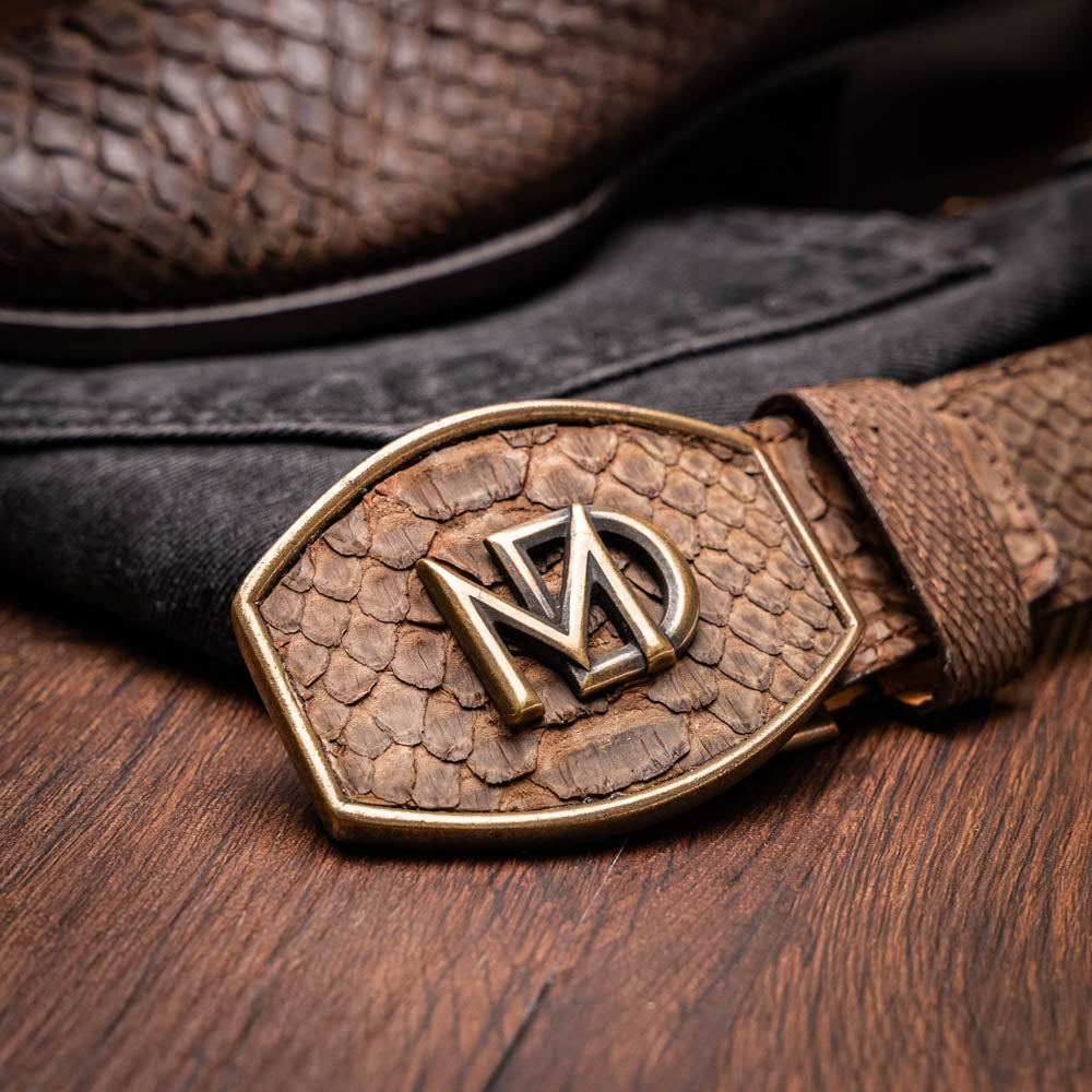 A pair of Kansas Brown textured luxury western boots by Marco Di Milano, featuring a pointed toe—one boot upright, the other showing the brand's logo on the leather sole.