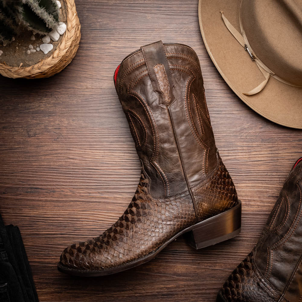 A pair of Kansas Brown textured luxury western boots by Marco Di Milano, featuring a pointed toe—one boot upright, the other showing the brand's logo on the leather sole.
