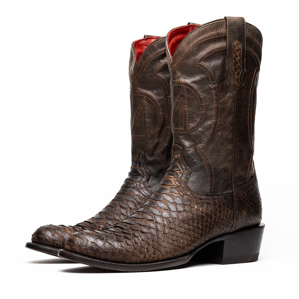 A pair of Kansas Brown textured luxury western boots by Marco Di Milano, featuring a pointed toe—one boot upright, the other showing the brand's logo on the leather sole.