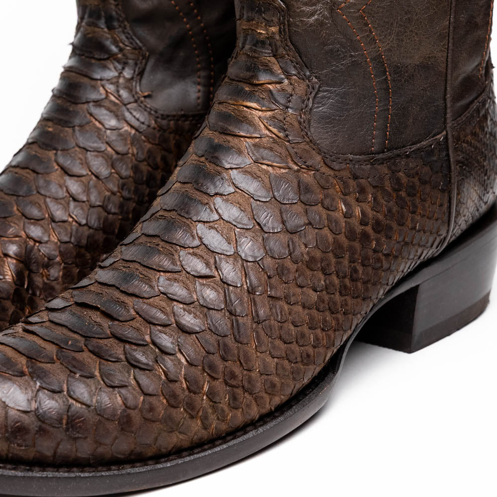 A pair of Kansas Brown textured luxury western boots by Marco Di Milano, featuring a pointed toe—one boot upright, the other showing the brand's logo on the leather sole.
