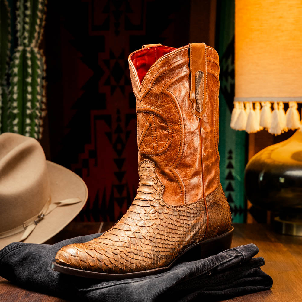 A pair of Kansas Cognac cowboy boots by Marco Di Milano in brown genuine python skin, featuring textured scales—one boot upright, the other showing the branded sole.