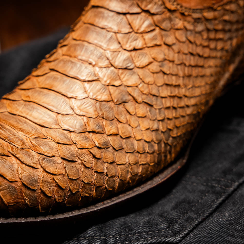 A pair of Kansas Cognac cowboy boots by Marco Di Milano in brown genuine python skin, featuring textured scales—one boot upright, the other showing the branded sole.
