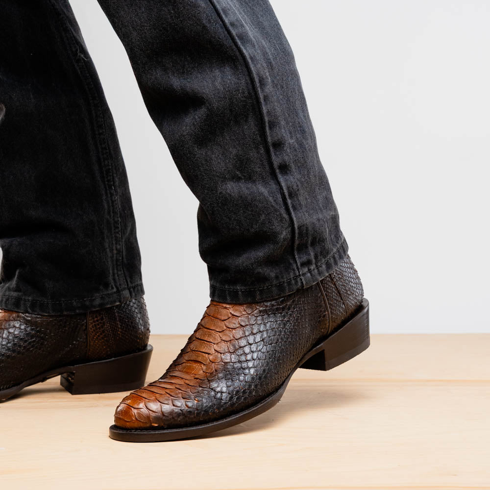 A pair of Kansas Lisboa boots by Marco Di Milano in brown and black python leather, featuring textured scales; one boot stands upright while the other displays the branded sole with "Marco Di Milano" text.