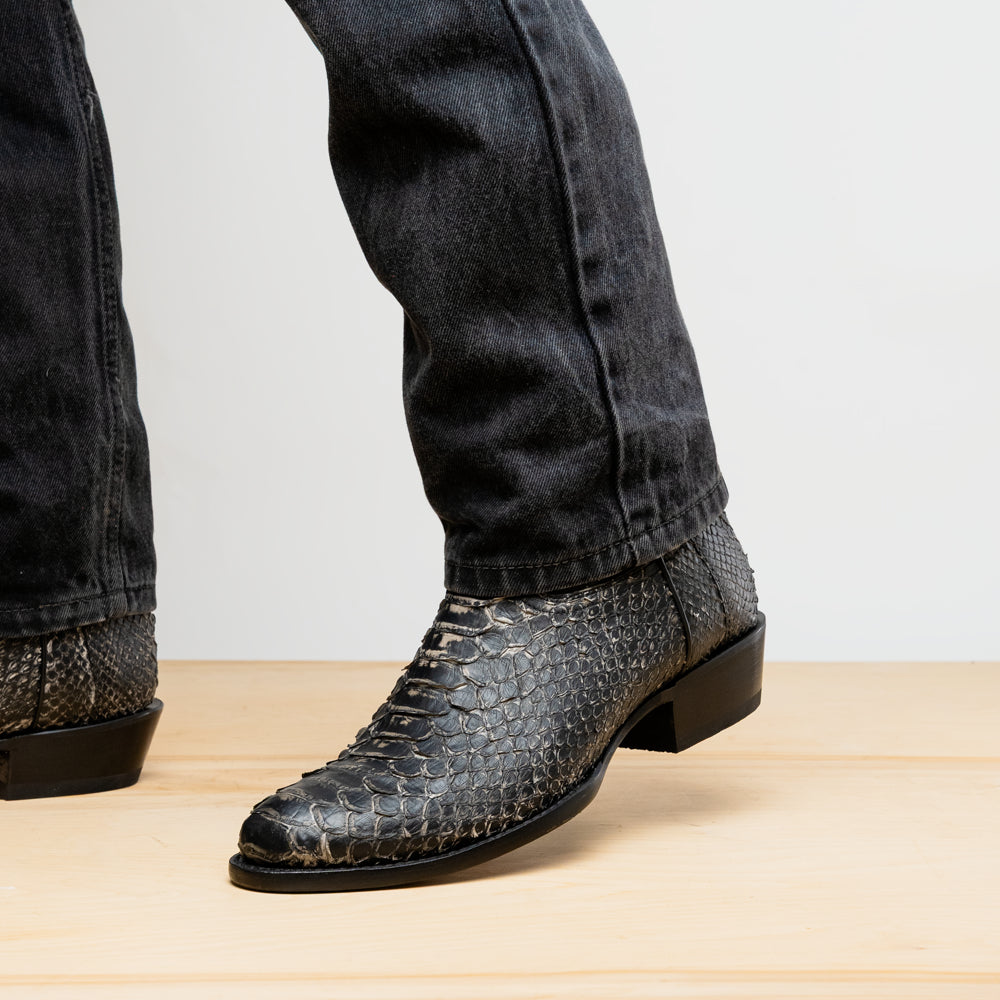 A pair of Kansas Stone White Western cowboy boots by Marco Di Milano, featuring textured, snakeskin-like leather and decorative stitching; one boot stands upright, the other shows the branded sole.