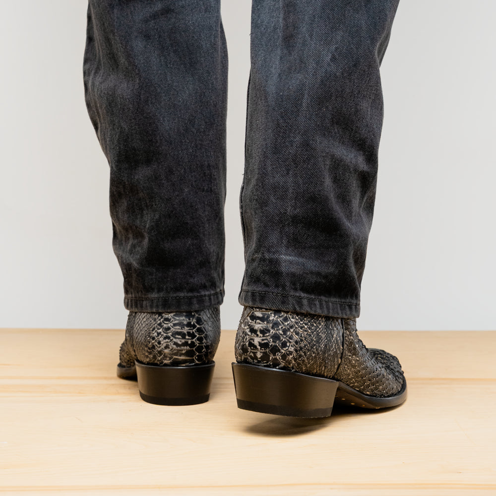 A pair of Kansas Stone White Western cowboy boots by Marco Di Milano, featuring textured, snakeskin-like leather and decorative stitching; one boot stands upright, the other shows the branded sole.