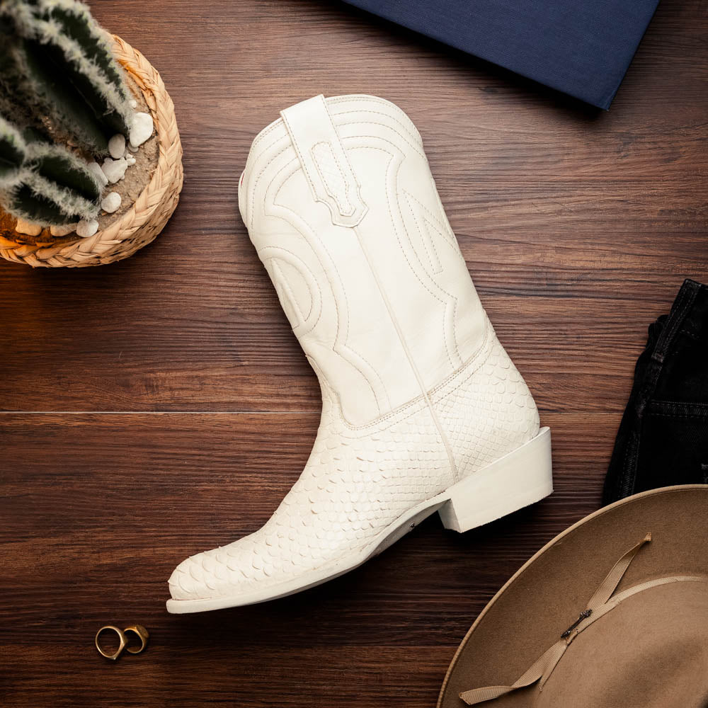 A pair of Kansas White cowboy boots by Marco Di Milano in white textured python skin with pointed toes and low heels; one boot stands upright while the other shows the branded sole.