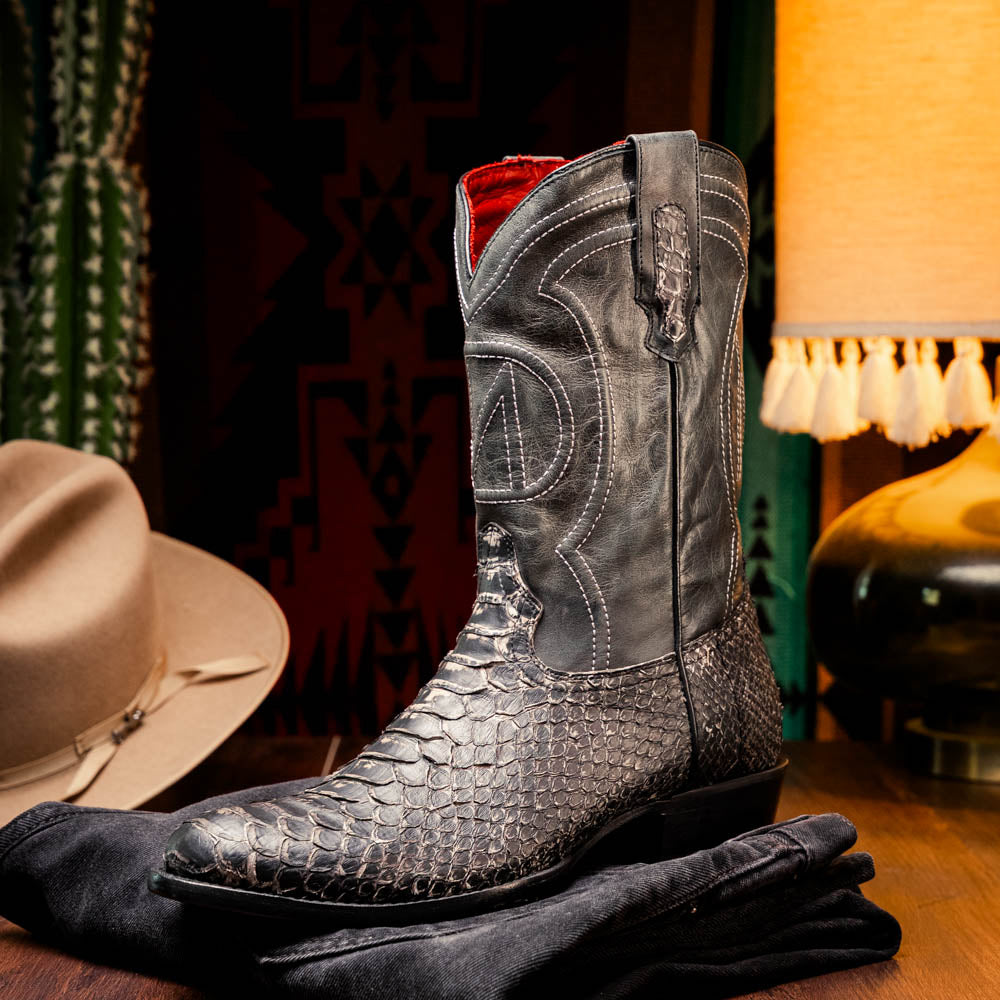 A pair of Kansas Stone White Western cowboy boots by Marco Di Milano, featuring textured, snakeskin-like leather and decorative stitching; one boot stands upright, the other shows the branded sole.