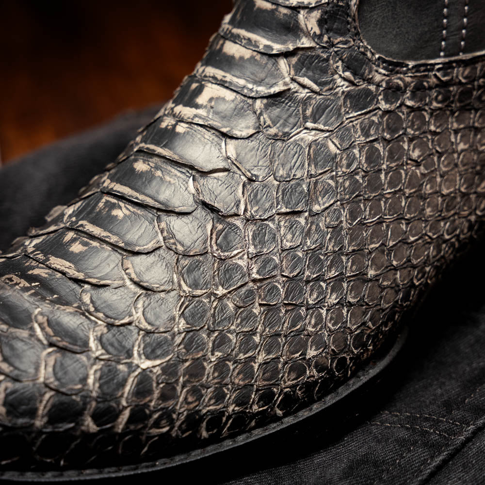 A pair of Kansas Stone White Western cowboy boots by Marco Di Milano, featuring textured, snakeskin-like leather and decorative stitching; one boot stands upright, the other shows the branded sole.