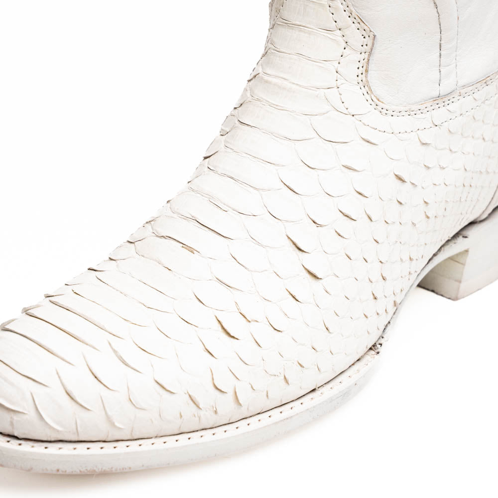 A pair of Kansas White cowboy boots by Marco Di Milano in white textured python skin with pointed toes and low heels; one boot stands upright while the other shows the branded sole.
