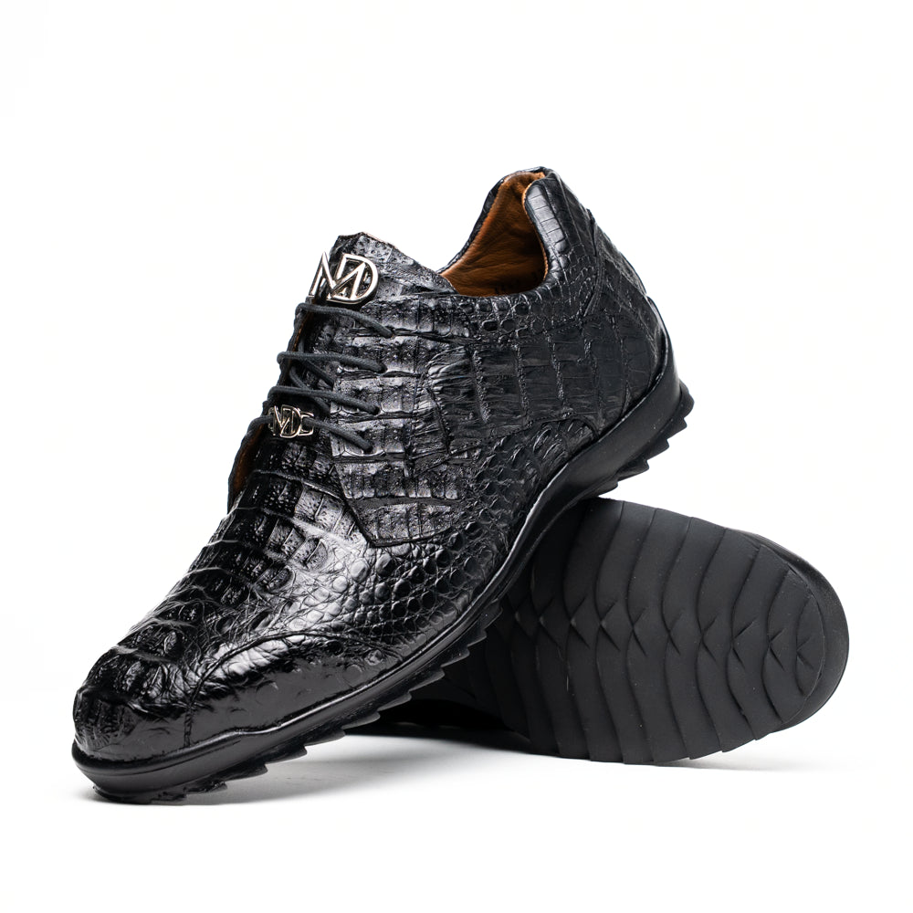 The Kratos Black by Marco Di Milano is a luxury black crocodile-patterned leather dress shoe, featuring a metal logo on the laces. Displayed with one upright and one on its side to showcase the detailed sole.