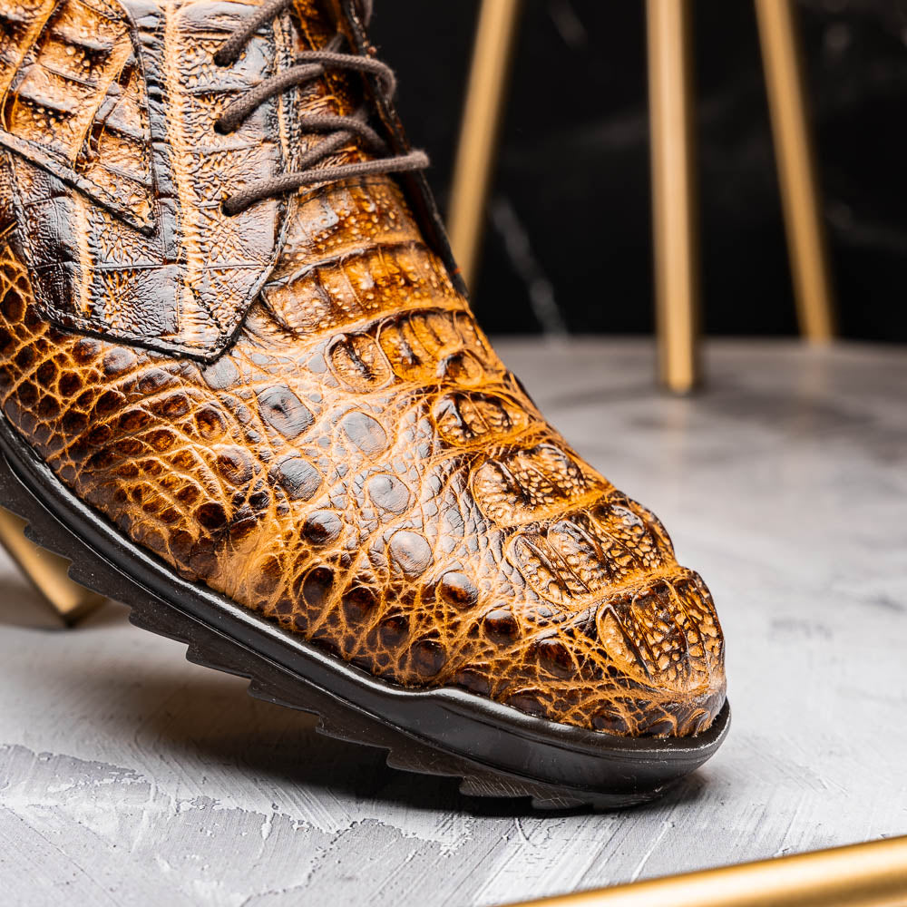 A pair of Kratos Rustic Orix brown crocodile-patterned leather dress shoes by Marco Di Milano, one upright and one tilted to display the textured sole, showcasing luxury footwear against a white background.