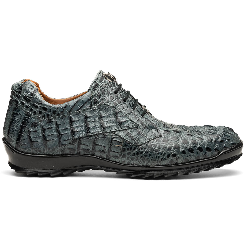 The Kratos Gray by Marco Di Milano are luxury dress shoes in textured gray crocodile-patterned leather with a hand-painted finish and black rubber soles; one shoe stands upright while the other rests on its side.