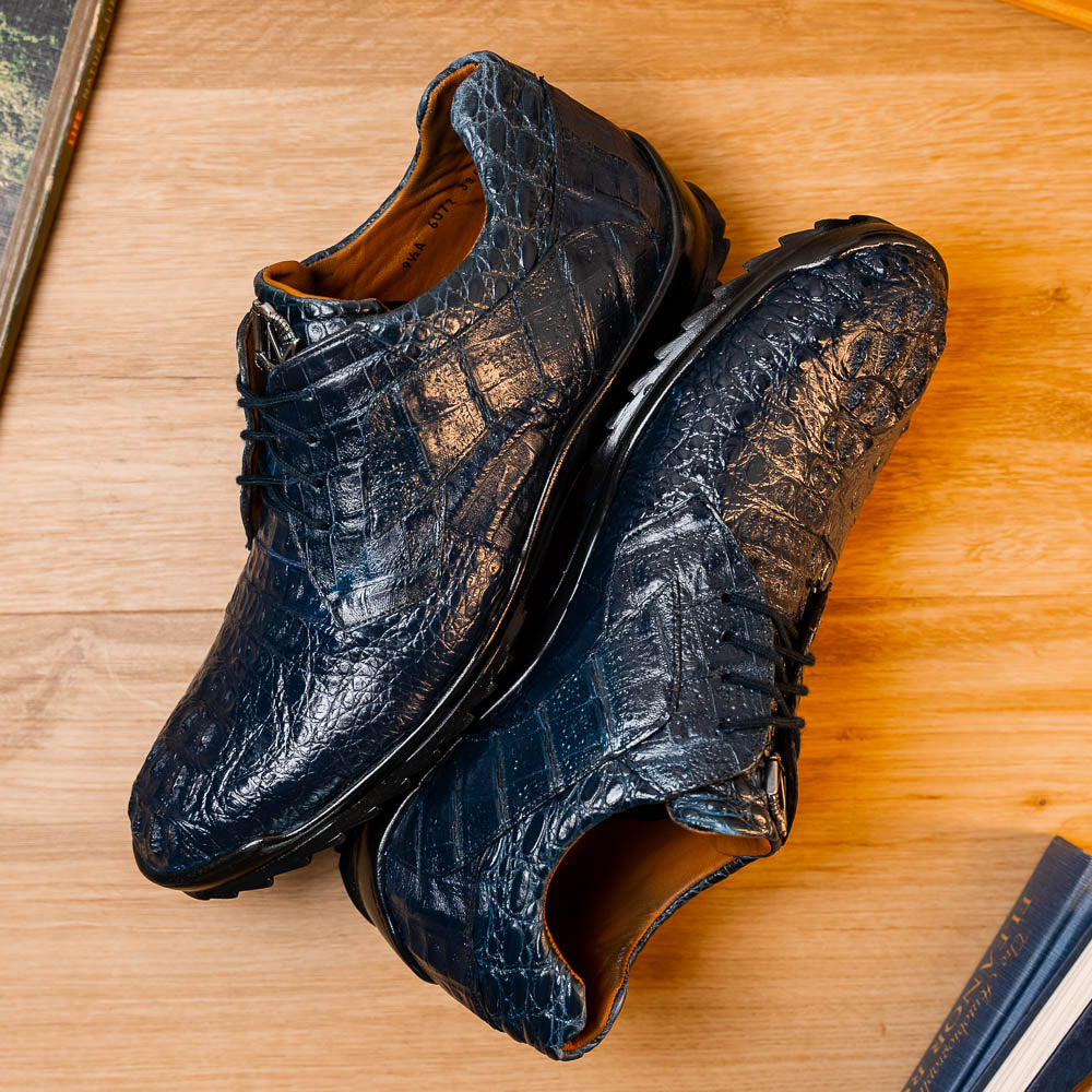 The Kratos Navy by Marco Di Milano: blue hand-painted crocodile-patterned leather dress shoes with black rubber soles—one upright, the other propped—a true statement of luxury footwear.