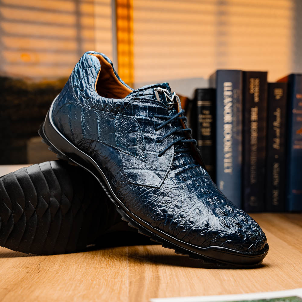 The Kratos Navy by Marco Di Milano: blue hand-painted crocodile-patterned leather dress shoes with black rubber soles—one upright, the other propped—a true statement of luxury footwear.