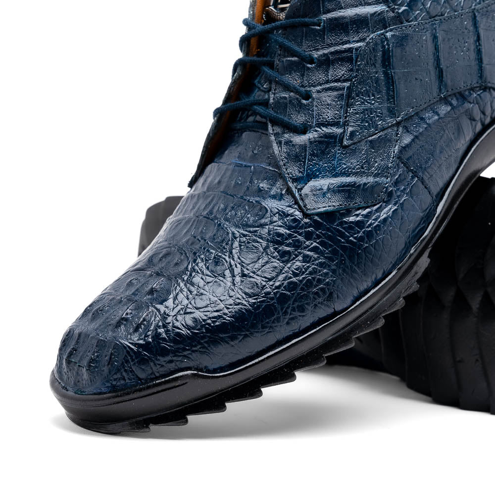 The Kratos Navy by Marco Di Milano: blue hand-painted crocodile-patterned leather dress shoes with black rubber soles—one upright, the other propped—a true statement of luxury footwear.