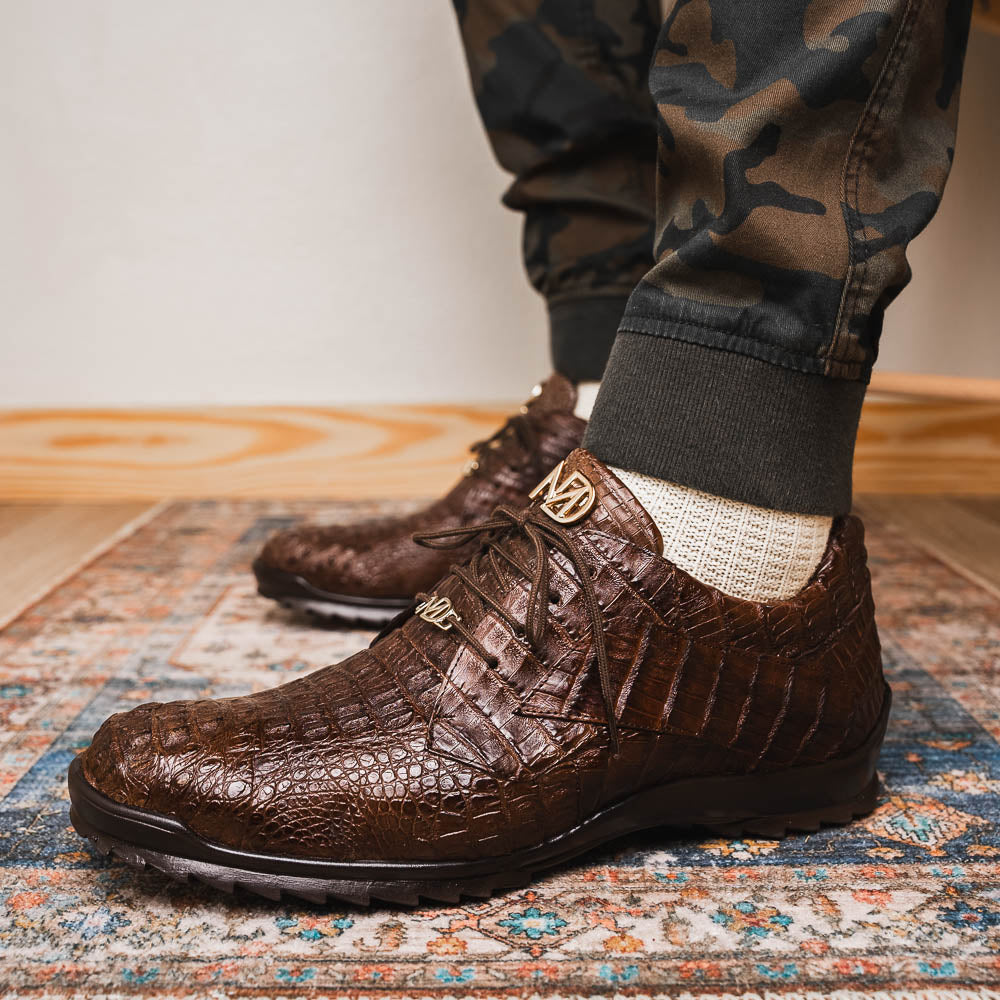 The Kratos Brown by Marco Di Milano features genuine caiman crocodile leather, a hand-painted brown finish, black soles, and gold lace accents—ideal luxury dress shoes for the discerning wearer.