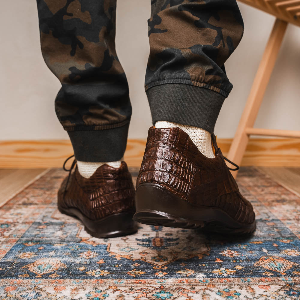 The Kratos Brown by Marco Di Milano features genuine caiman crocodile leather, a hand-painted brown finish, black soles, and gold lace accents—ideal luxury dress shoes for the discerning wearer.