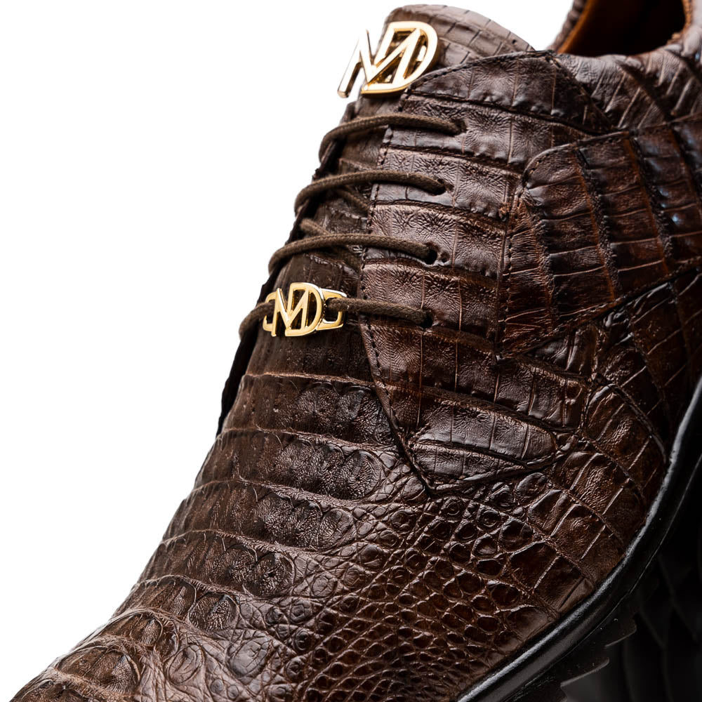 The Kratos Brown by Marco Di Milano features genuine caiman crocodile leather, a hand-painted brown finish, black soles, and gold lace accents—ideal luxury dress shoes for the discerning wearer.