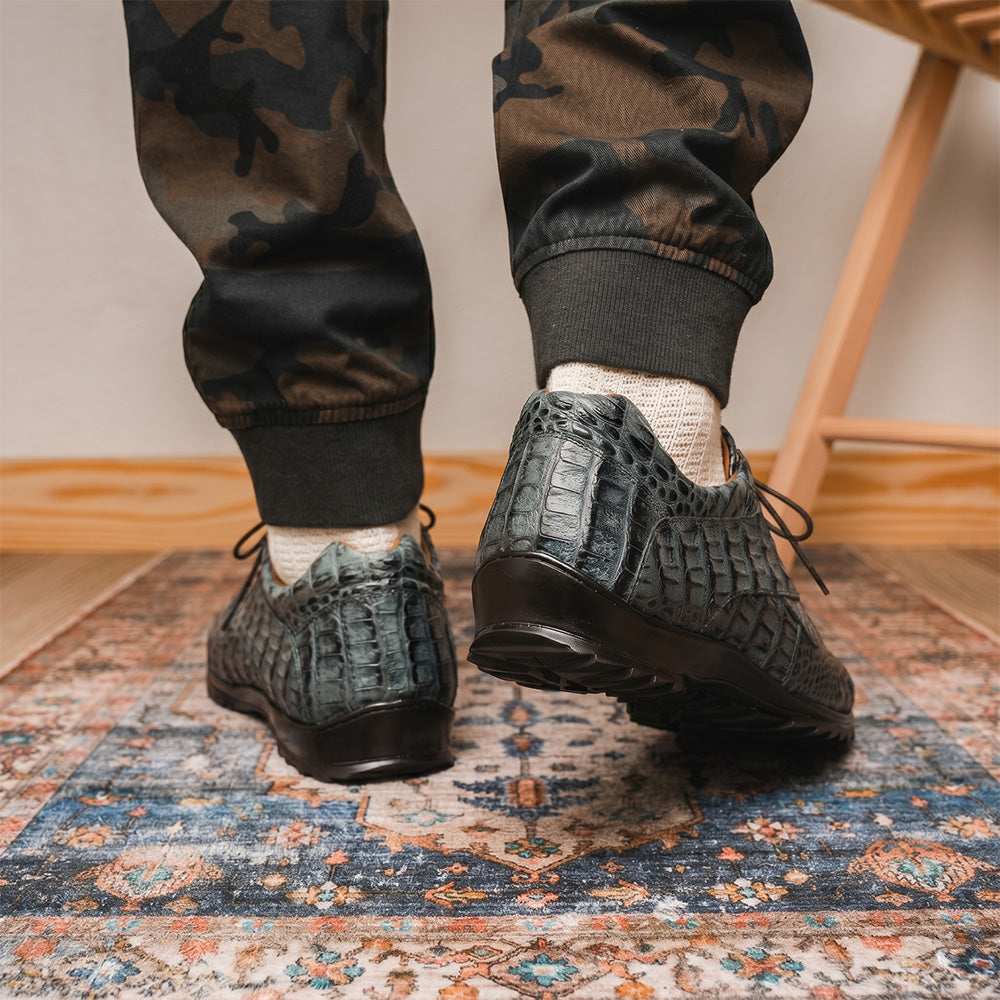 The Kratos Gray by Marco Di Milano are luxury dress shoes in textured gray crocodile-patterned leather with a hand-painted finish and black rubber soles; one shoe stands upright while the other rests on its side.