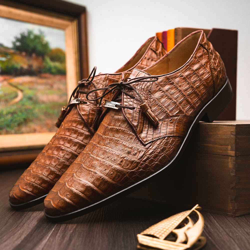 A pair of Marco Di Milano Lacio Bay Apache luxury derby shoes crafted from genuine caiman crocodile leather—one upright and the other on its side to showcase the exquisite sole.