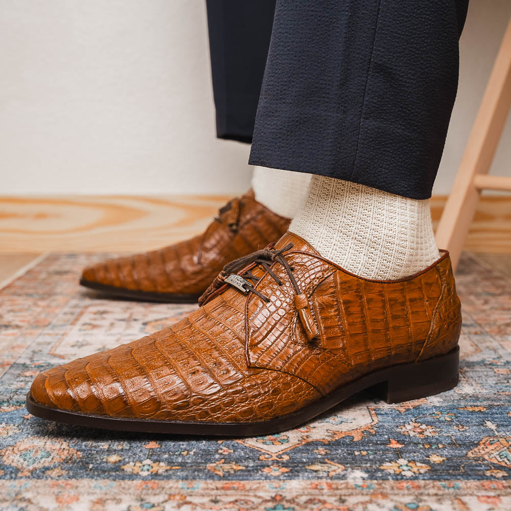 A pair of Marco Di Milano Lacio Bay Apache luxury derby shoes crafted from genuine caiman crocodile leather—one upright and the other on its side to showcase the exquisite sole.