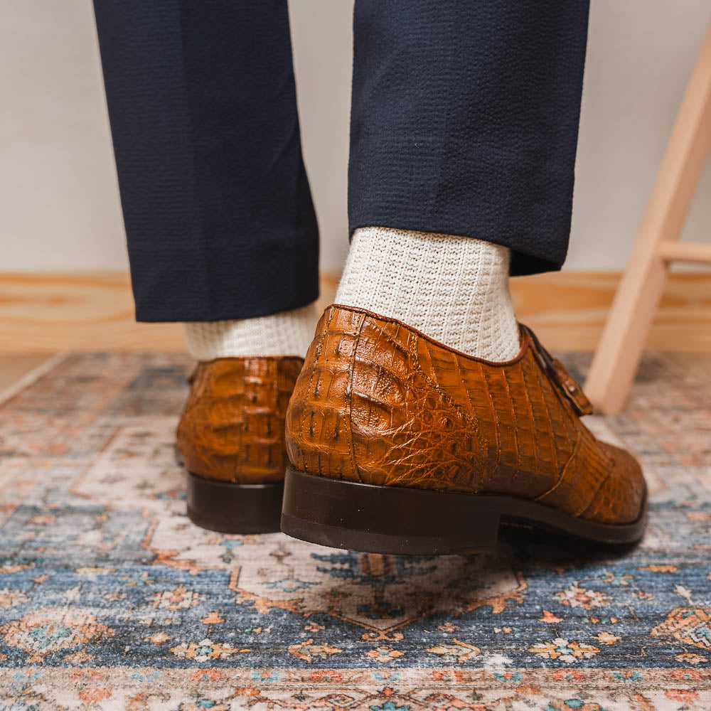 A pair of Marco Di Milano Lacio Bay Apache luxury derby shoes crafted from genuine caiman crocodile leather—one upright and the other on its side to showcase the exquisite sole.