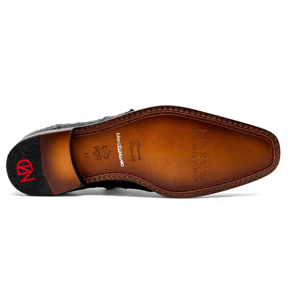 A pair of Marco Di Milano Lacio Black shoes—crafted from genuine caiman crocodile leather—one upright and one on its side, showing a brown leather sole embossed with luxury branding.
