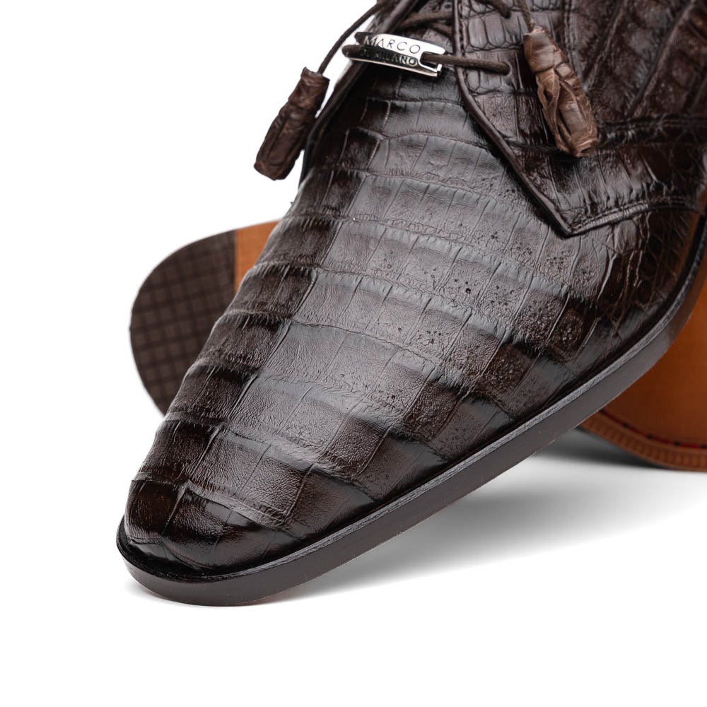 The "Lacio Brown" by Marco Di Milano is a luxury men's dress shoe made from genuine caiman crocodile leather, featuring tassel laces and the brand's logo—presented with one shoe resting atop the other.