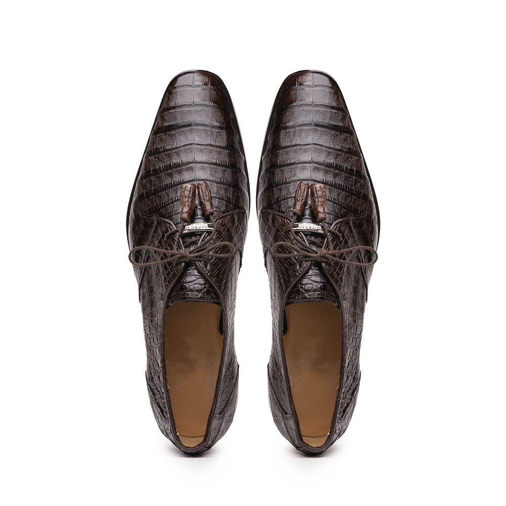The "Lacio Brown" by Marco Di Milano is a luxury men's dress shoe made from genuine caiman crocodile leather, featuring tassel laces and the brand's logo—presented with one shoe resting atop the other.
