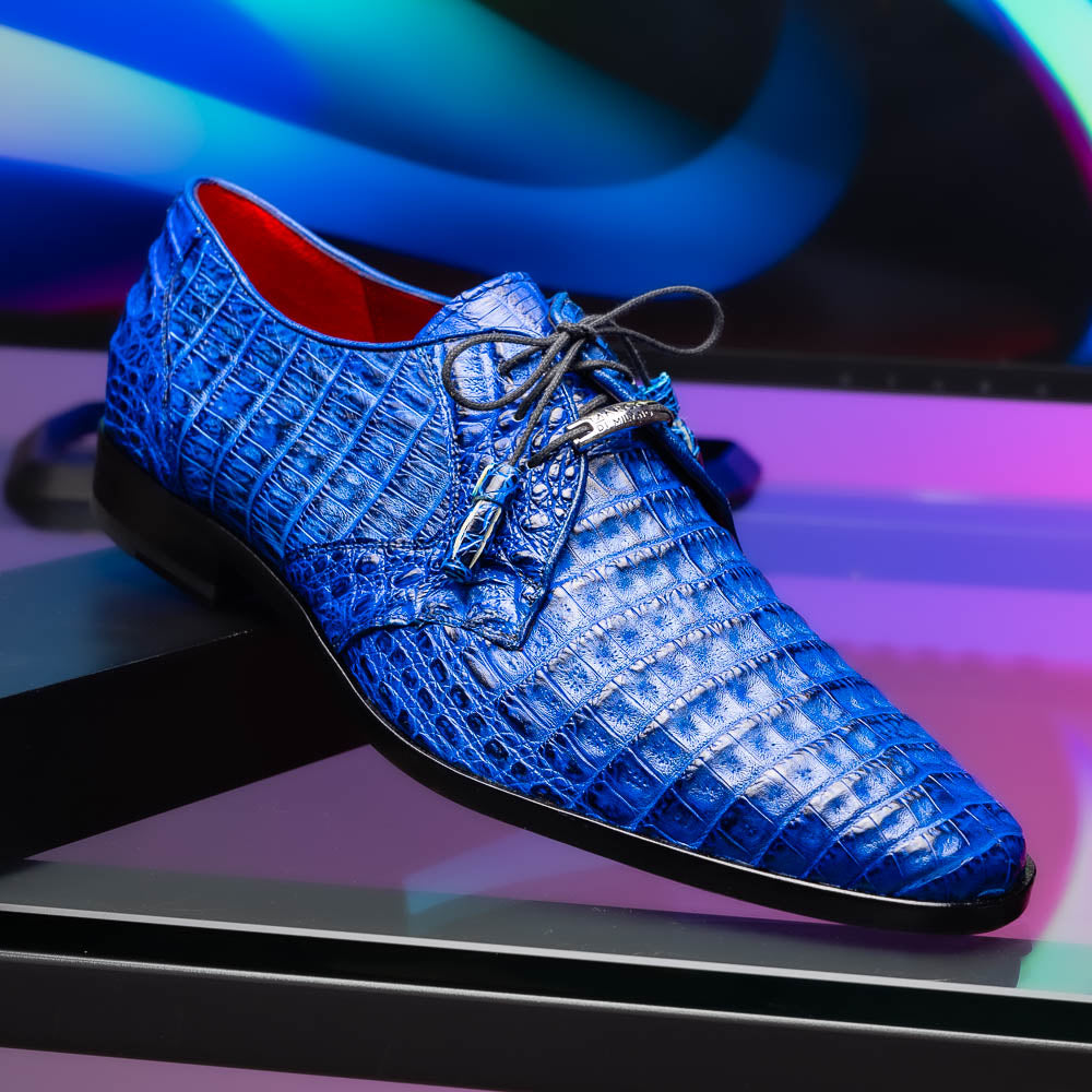 Marco Di Milano’s Lacio Electric Blue men’s dress shoes feature genuine caiman crocodile leather in blue, black laces, a bold red interior, with one shoe standing upright and the other lying on its side.