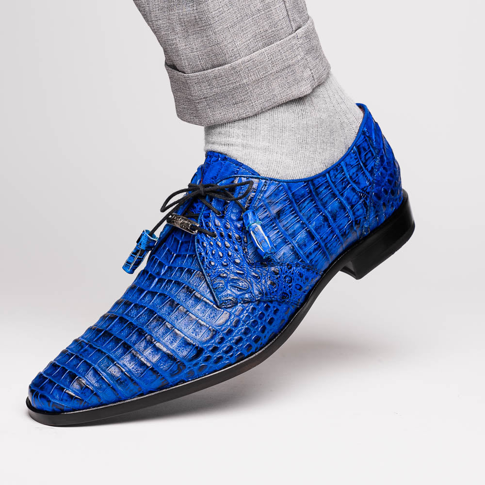 Marco Di Milano’s Lacio Electric Blue men’s dress shoes feature genuine caiman crocodile leather in blue, black laces, a bold red interior, with one shoe standing upright and the other lying on its side.