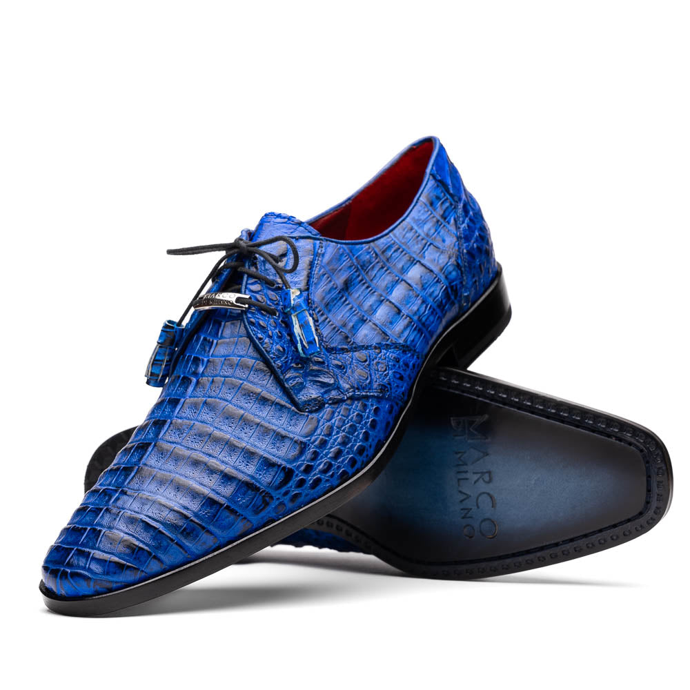 Marco Di Milano’s Lacio Electric Blue men’s dress shoes feature genuine caiman crocodile leather in blue, black laces, a bold red interior, with one shoe standing upright and the other lying on its side.
