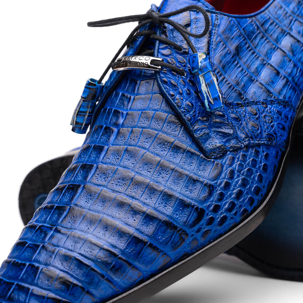 Marco Di Milano’s Lacio Electric Blue men’s dress shoes feature genuine caiman crocodile leather in blue, black laces, a bold red interior, with one shoe standing upright and the other lying on its side.