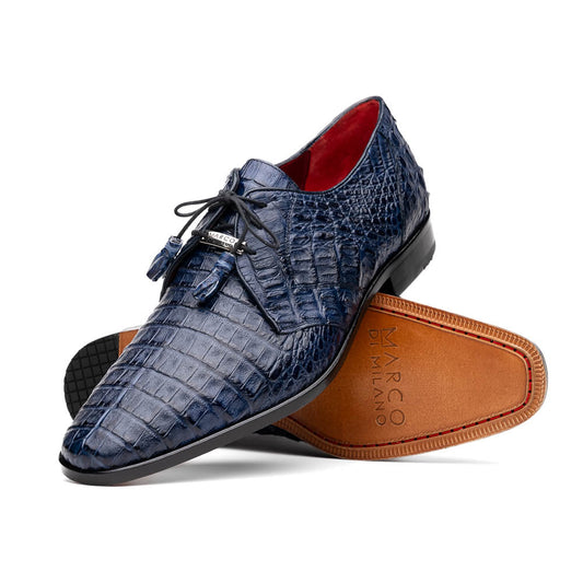 The Lacio Navy by Marco Di Milano are luxury dress derby shoes made from genuine caiman crocodile leather, featuring elegant tassels, a red interior lining, and tan leather soles stamped with the brand’s name.