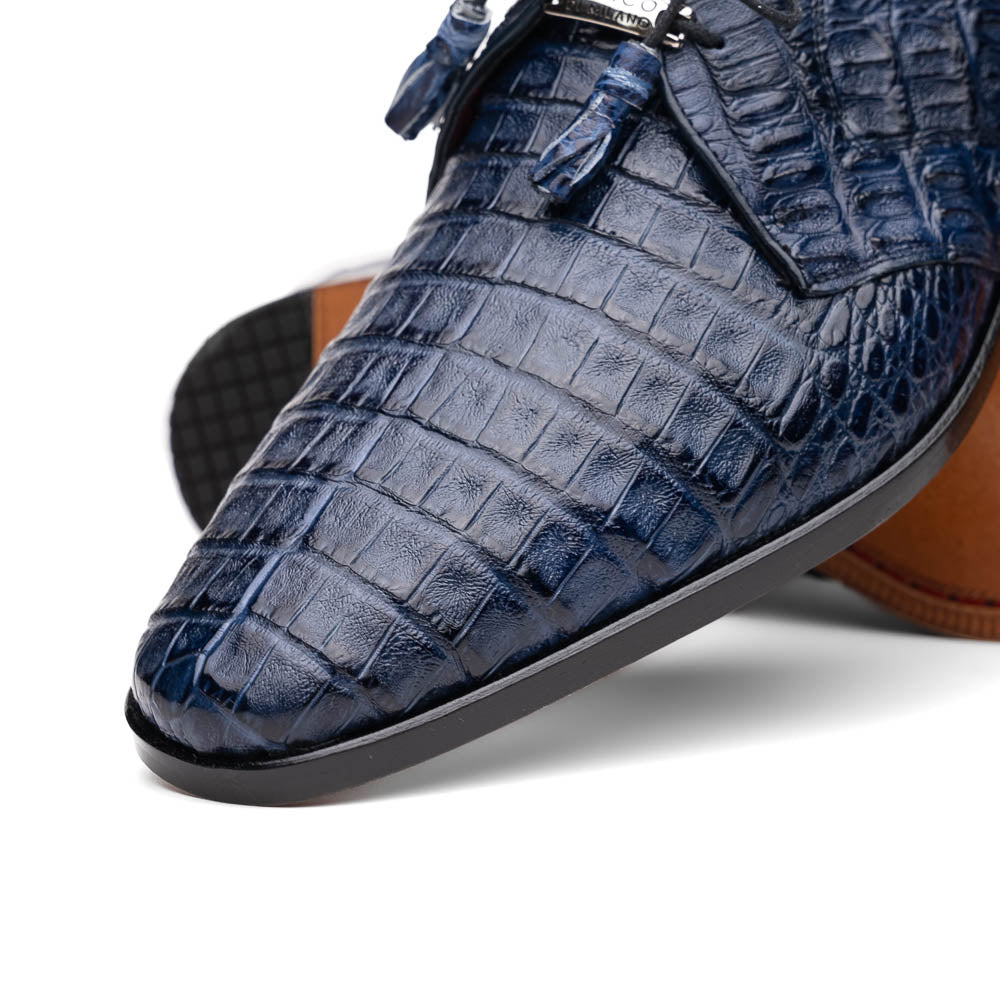 The Lacio Navy by Marco Di Milano are luxury dress derby shoes made from genuine caiman crocodile leather, featuring elegant tassels, a red interior lining, and tan leather soles stamped with the brand’s name.