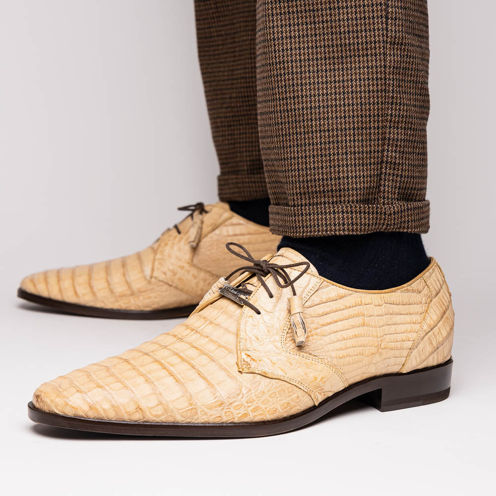 A pair of beige Marco Di Milano Lacio Orix shoes in genuine caiman crocodile, featuring a luxury derby design with dark brown laces—one upright, the other on its side to display the detailed sole.