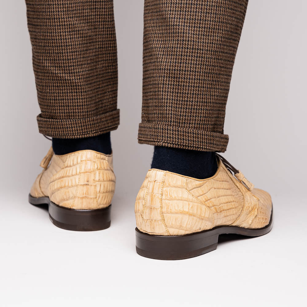A pair of beige Marco Di Milano Lacio Orix shoes in genuine caiman crocodile, featuring a luxury derby design with dark brown laces—one upright, the other on its side to display the detailed sole.